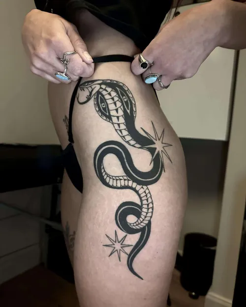 Blackwork cobra tattoo on a hip