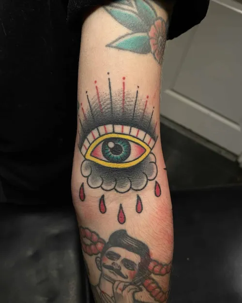 Traditional colour tattoo of an eye with a cloud and drops