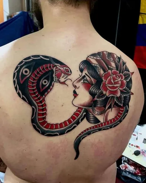 Traditionell tatuering av en flicka som tittar på en orm