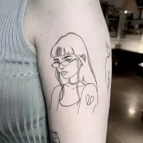 Fine line tattoo of a girl with glasses on an upper arm