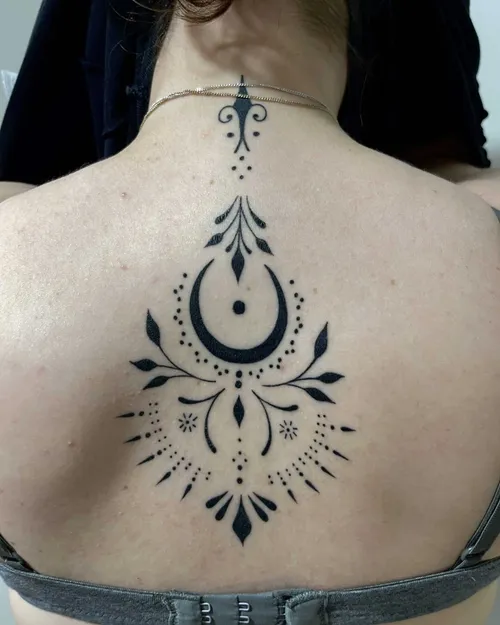 Blackwork ornamental crescent moon on an upper back