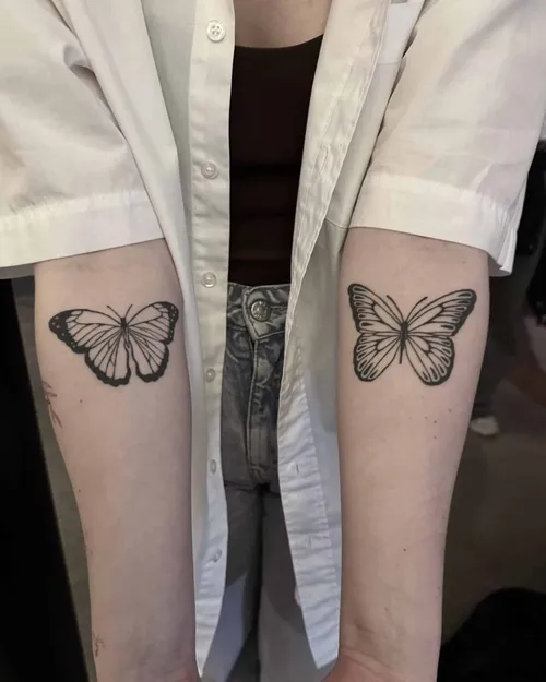 Matching blackwork butterflies on both forearms